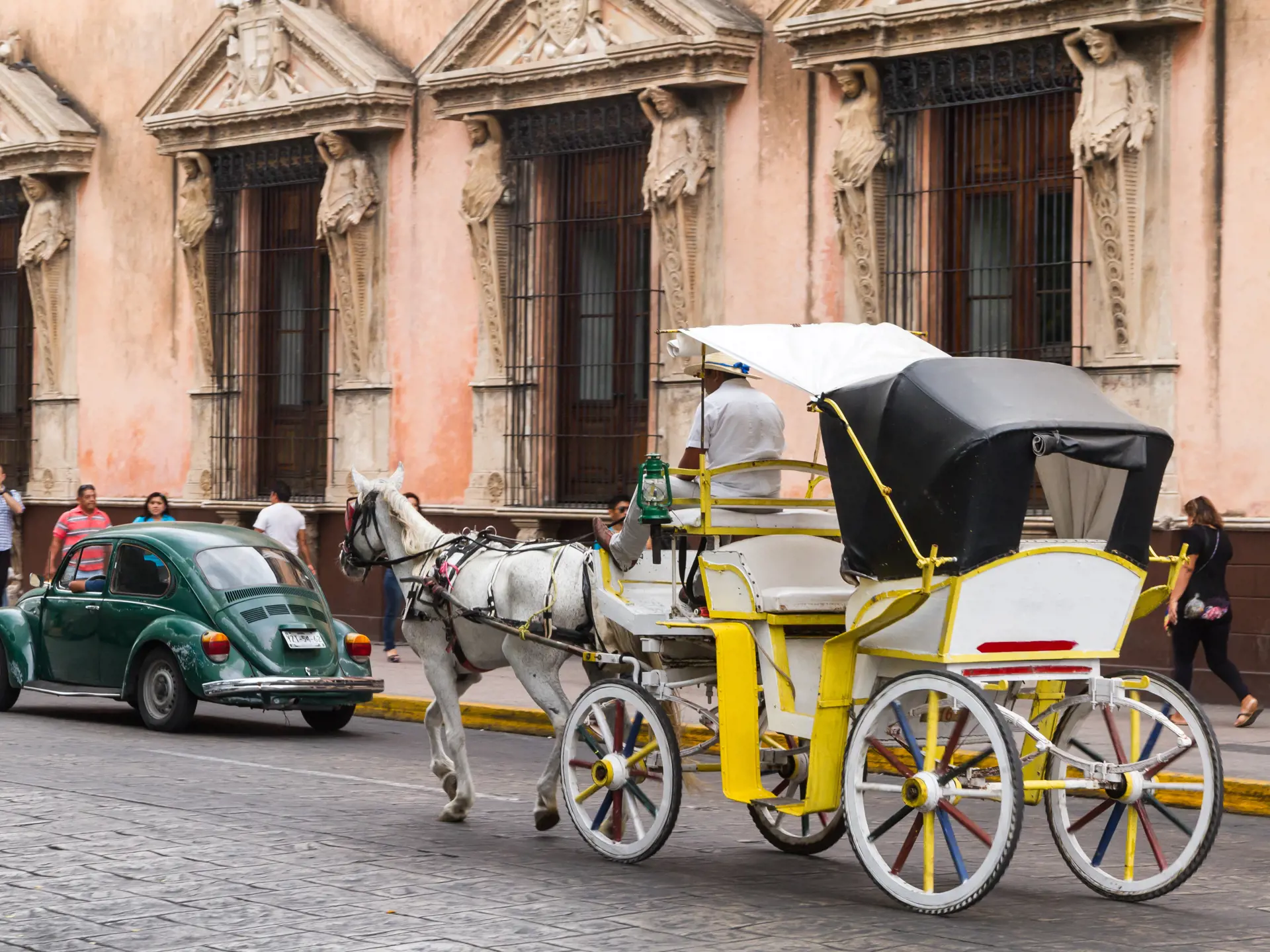 shutterstock_279300569 Horse carriages with passengers on a city street in Merida Mexico..jpg