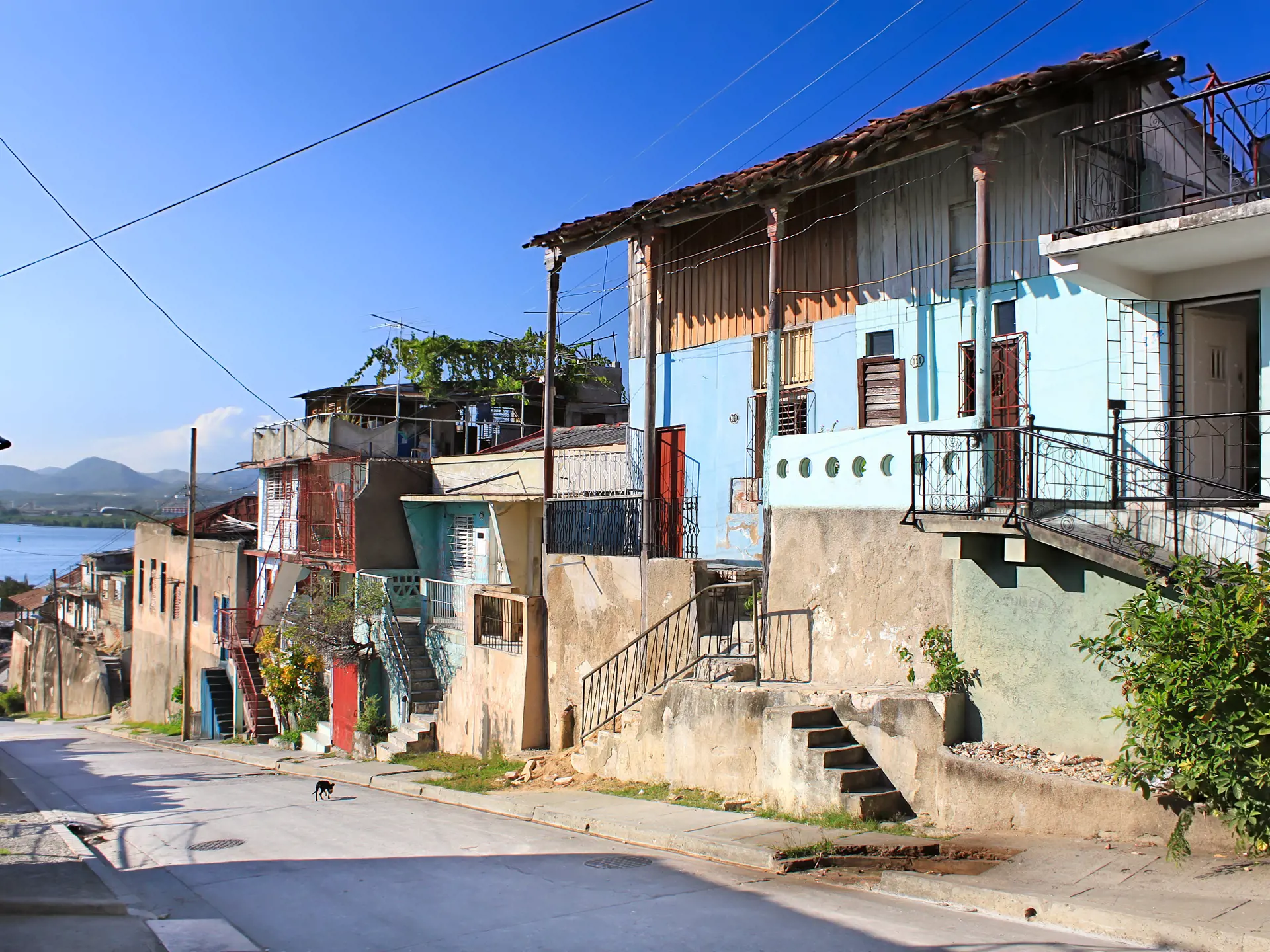 shutterstock_49509832 Panoramic view of street with crumbling buildings and view on a bay in Santiago de Cuba , Cuba.jpg