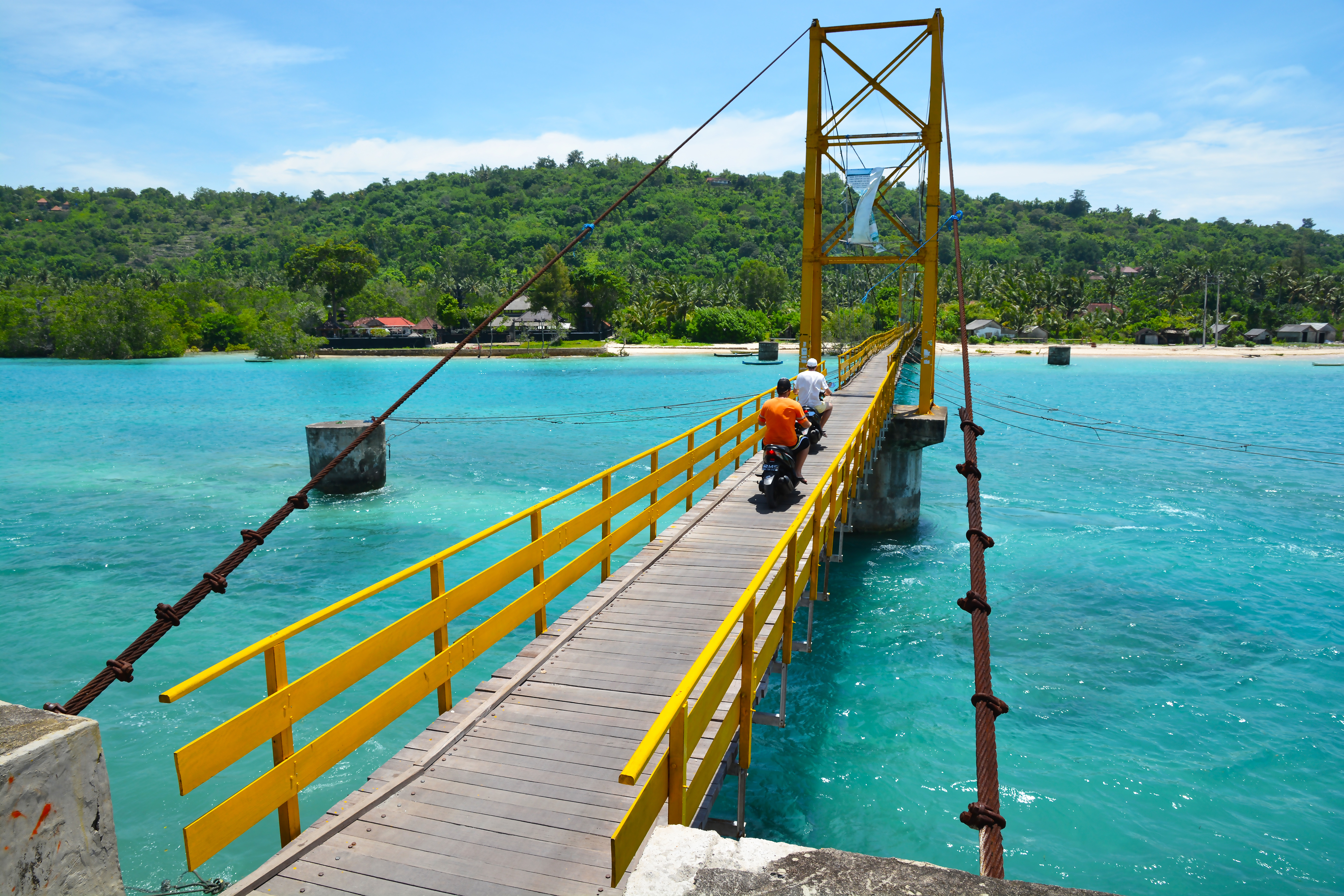 Shutterstock 1866215935 (Two Men Drive Scooters Across Bridge On Nusa Lembongan, Indonesia.)