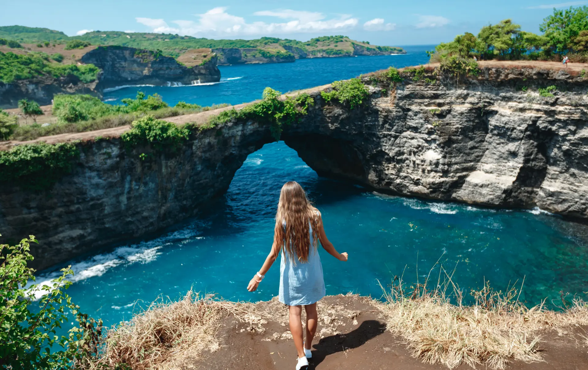 Shutterstock 1485852206 (Back View Woman On The Edge Of A Cliff Looking On Broken Beach. Broken Beach Nusa Penida Popular Travel Destination In Indonesia)