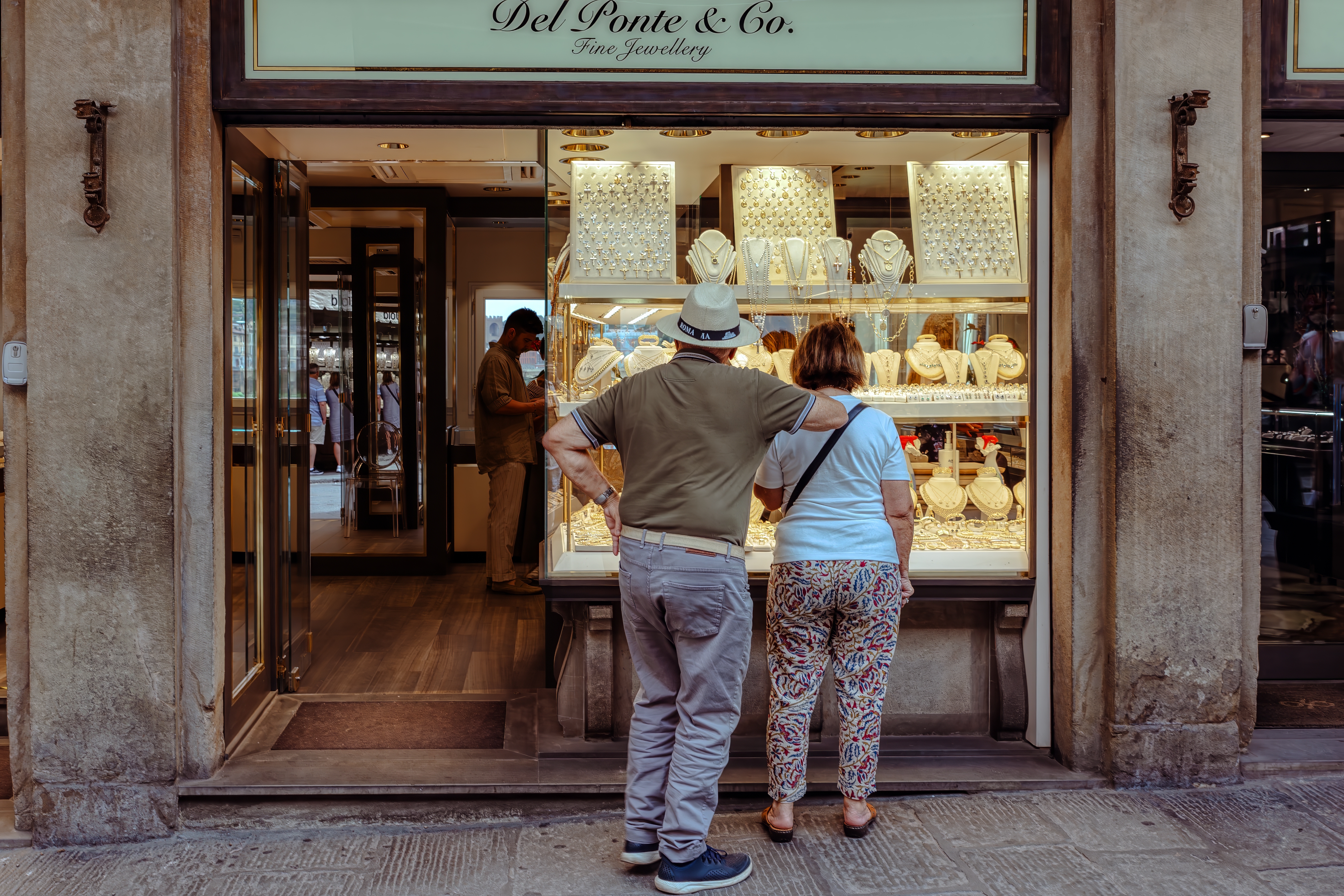 Shutterstock 2542957613 Firenze, Italien 20. Juni 2024 Et Par Ældre Turister Ved Vinduet I En Smykkebutik Nær Ponte Vecchio Broen I Firenze